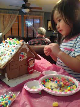 Anna decorating a gingerbread house