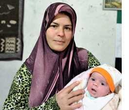 Khadoug Sawady, a Syrian refugee, holds her infant daughter 