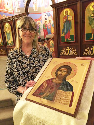 My friend took this picture of me with one of the two icons I wrote for the stands in front of the solea at St. John Orthodox Church. The worn spot is where worshipers have kissed the icon. I never learned to seal egg tempera very well.