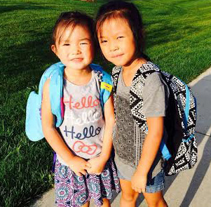 Anna and Grace with new backpacks off to new school.