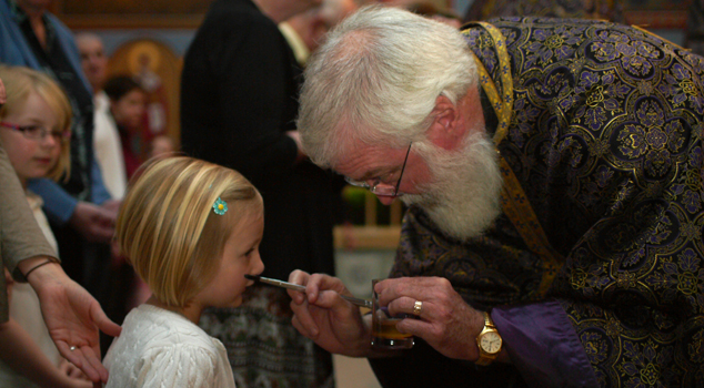 Father John Troy Mashburn annointing parishioners with holy oil during Unction at St. John Orthodox Church.